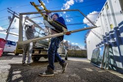 Glass installer at work carries pane to vehicle - Get Noise free home with secondary glazing